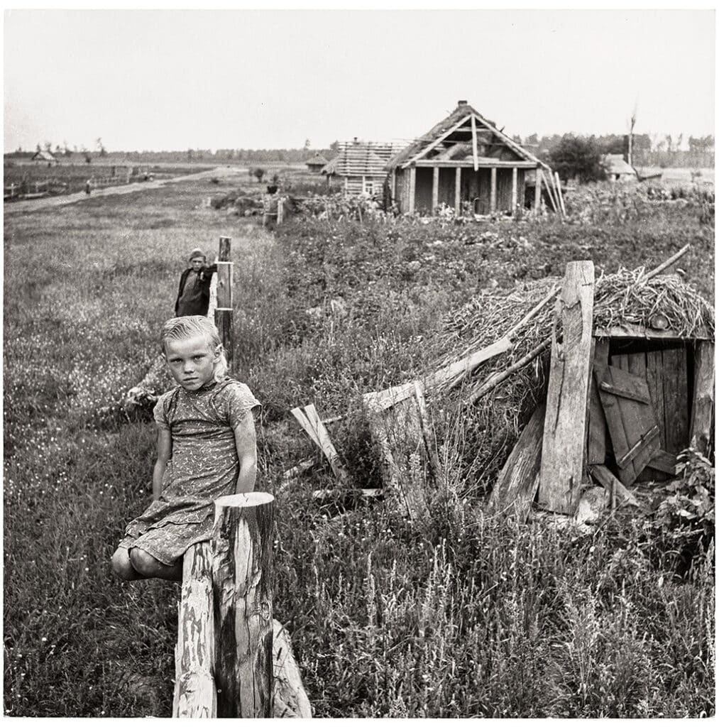 Girl sitting on a wooden fence on a collective farm, Ukraine, USSR, 1947