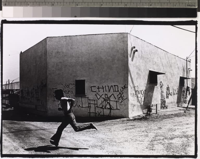 Gusmano Cesaretti. Chaz Running: a back street near Whittier Boulevard, East Los Angeles, 1973. Courtesy of the artist.
