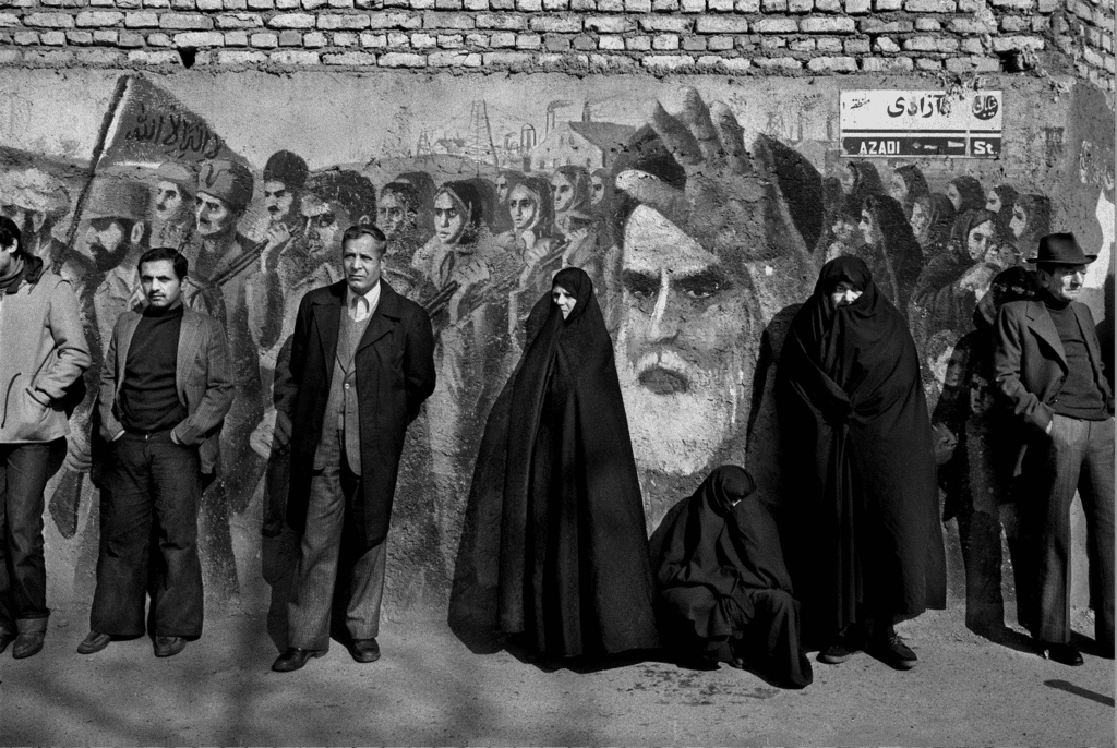 On the 4th anniversary of the revolution, bystanders stand in front of a mural on Azadi Street (Azadi meaning freedom) in Tehran, 1983 © Manoocher Deghati