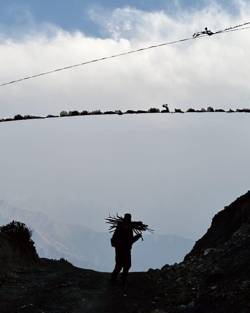 Un berger portant du bois pour se réchauffer la nuit. Au sommet d’un col du Mustang. © Samuel Urtado