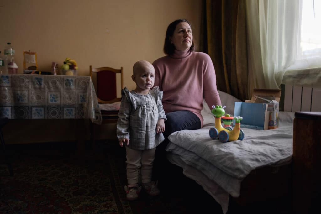 Elina with her mother in the apartment they live near Lviv, Feb 9, 2023. Elina and her family were forced to flee their home in Kharkiv due to the Russian bombardment. After arriving at a refugee camp in the west of the country, Elina was diagnosed with leukemia. She was the third child since the start of the conflict to undergo bone marrow surgery at Lviv. © Fabio Bucciarelli