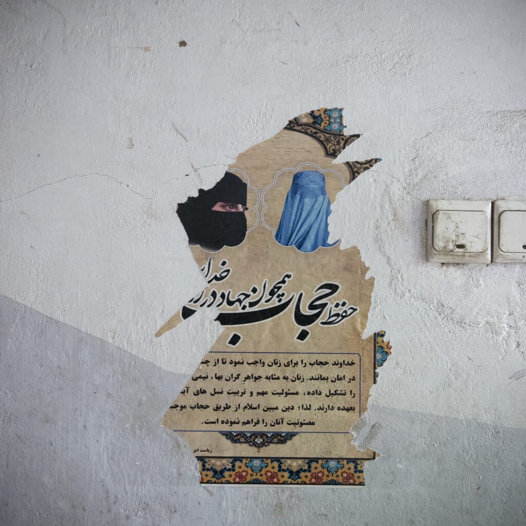 Aizabad, Badakhshan, Afghanistan | May, 11, 2024. A ripped poster shows how women are supposed to cover their faces: with a burqa, or chadari, a full face covering, or with a niqab, allowing only the eyes to be uncovered. © Kiana Hayeri for Fondation Carmignac