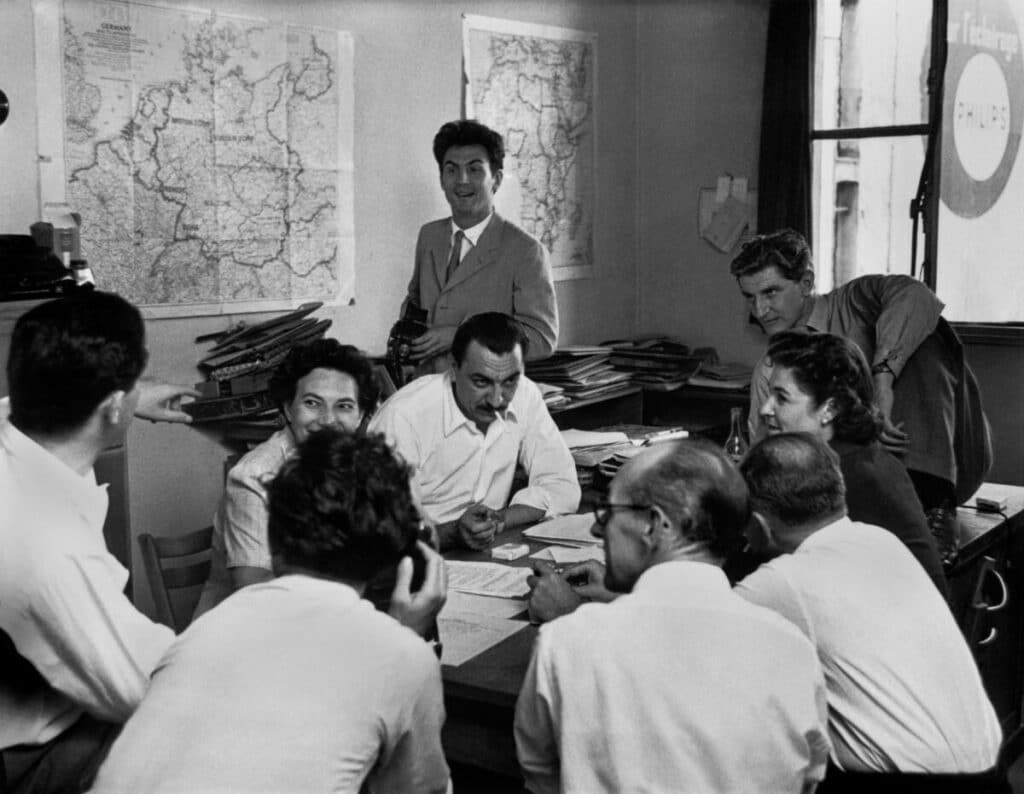 A Magnum Photos meeting. From left to right: Robert Capa, Maria Eisner, Alberto Mondadori (Epoca), Ernst Haas (standing), George Rodger, Joan Bush, David Seymour, Leonard Spooner (Illustrated). Paris, France. 1950. © Werner Bischof / Magnum Photos