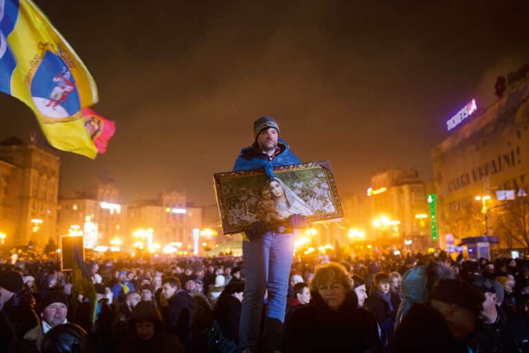 A man listens to a speech by President Petro Poroshenko marking the first anniversary of the Revolution of Dignity on Maidan Nezalezhnosti on February 20, 2015 in Kyiv, Ukraine. February 20th is recognized as the bloodiest day of the revolution, and is used to commemorate the ‘Heavenly Hundred’ who were killed during the uprising. © Pete Kiehart