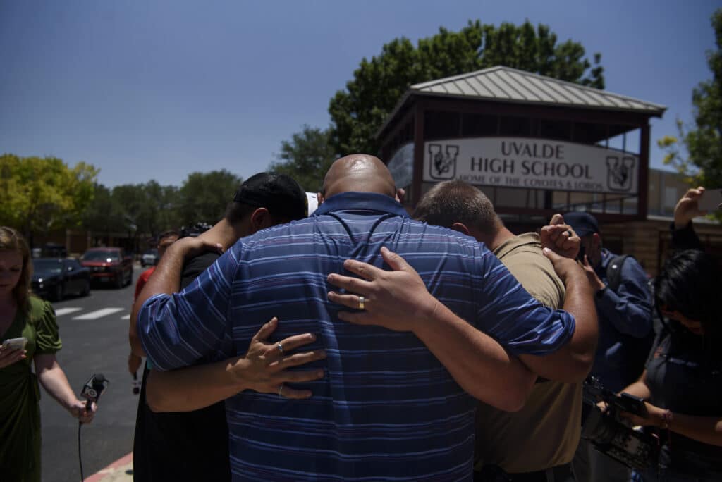 May 25th, 2022. Uvalde, Texas. A group of people pray following a press conference at Uvalde High School. © Callaghan O’Hare for The New York Times